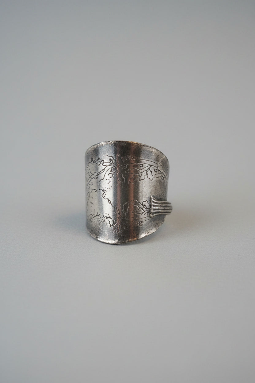 A recycles vintage thistle spoon ring , displayed on a black cushion inside a wooden jewelry box.